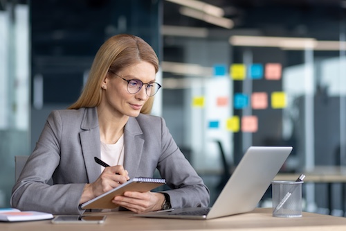 A businesswoman researching on a laptop