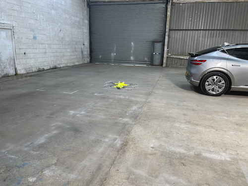 industrial unit with a car and a yellow stuffed toy on the floor